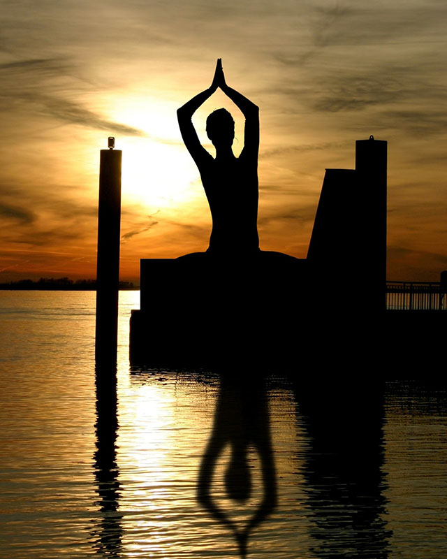 Statue meditierender Buddha im Sonnenuntergang im Meer_als Sinnbild für den Rutengänger oder Mensch im Gleichgewicht_In der Rutengehen Ausbidlung durch den Forschunsgkreis für Geobiologie lernst du dich ins Gleichgewicht zu bringen